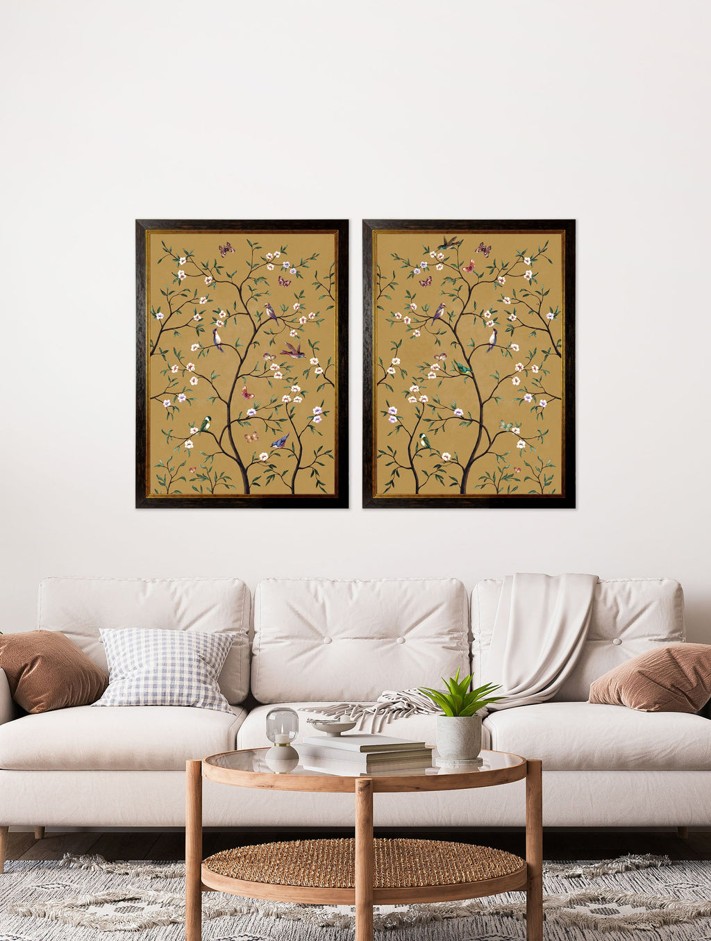 Two framed floral artworks on a wall above a white sofa with decorative pillows.