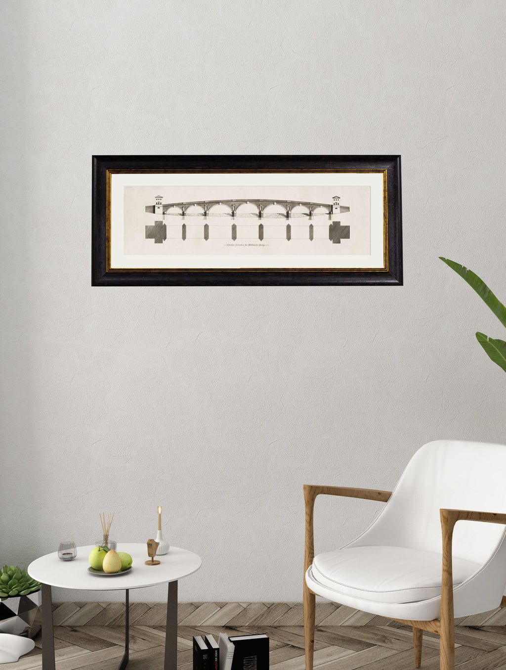 Framed architectural drawing on a wall above a table with decor items and a chair.